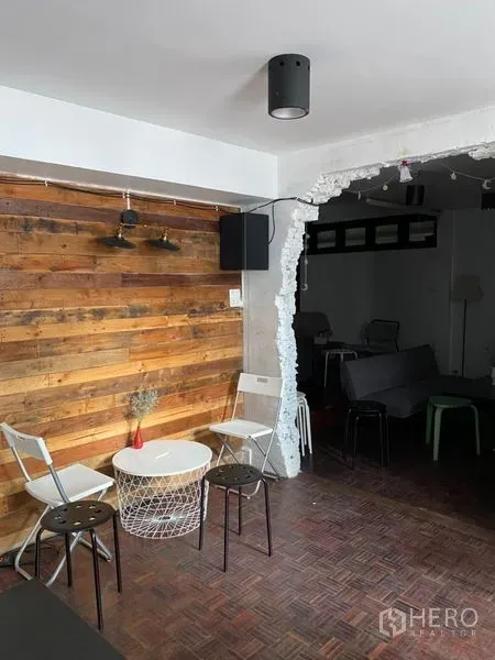 Home Office for rent in Pathum Wan, Bangkok - Cozy seating corner with white round table, stools and rustic wood feature wall.