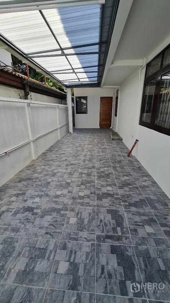 独栋房屋 for rent in Lat Phrao, Bangkok - 房屋侧边带遮雨顶棚的瓷砖地露台/车位。