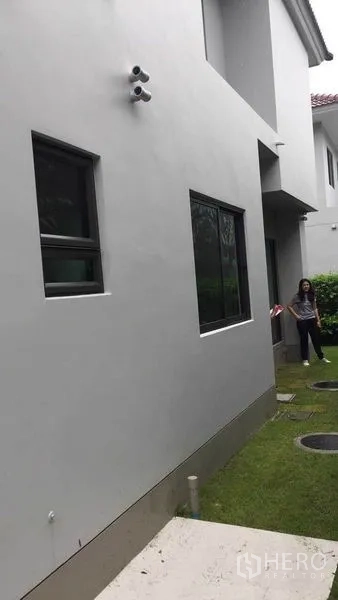 บ้าน ขายในPak Kret, Nonthaburi - ผนังภายนอกสีขาวพร้อมหน้าต่าง มองเห็นสนามหญ้าข้างบ้าน