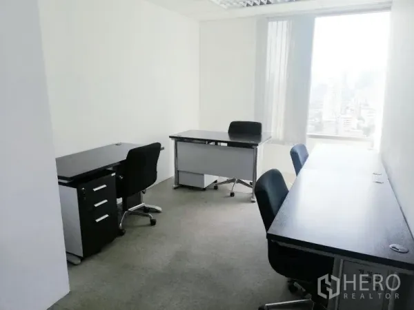 Office Space for rent in Ratchathewi, Bangkok - Compact private office with workstations, task chairs and a window showcasing a city view.
