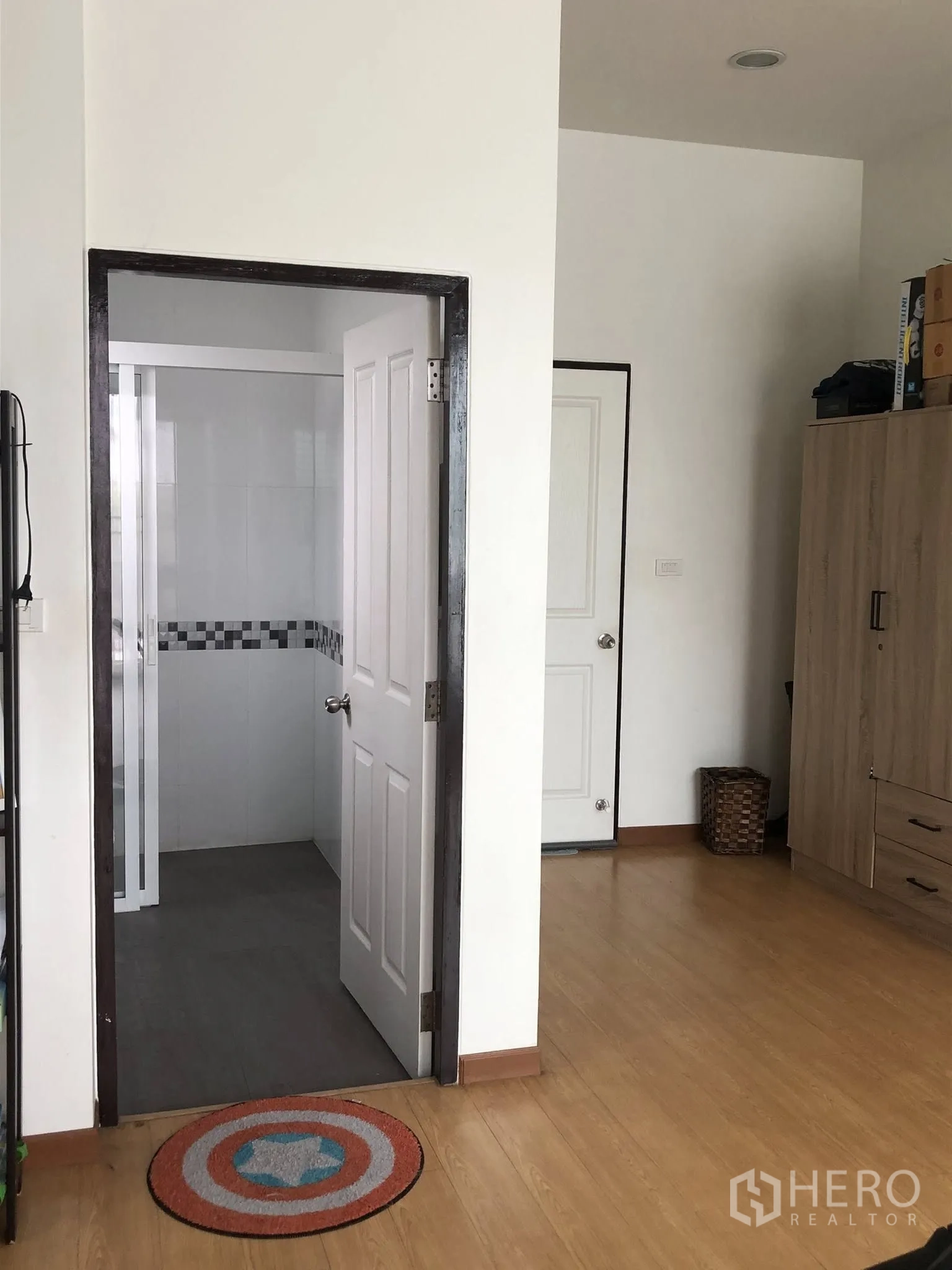 Townhouse for sale in Phra Khanong, Bangkok - Bedroom area with en-suite bathroom doorway and a built-in wardrobe.