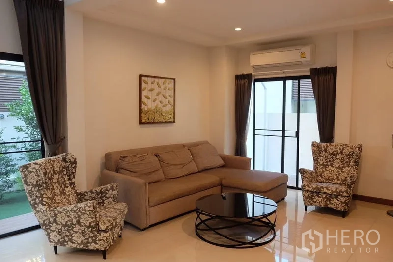 Detached House for rent in Bang Phli, Samut Prakan - Spacious lounge with sofa, armchairs and door to balcony or garden.