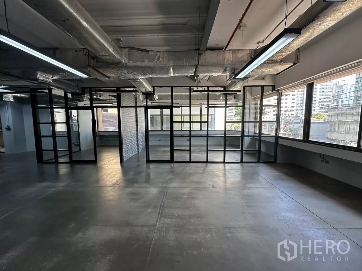 Office Space for rent - Open office with large windows and city views, framed glass partitions.