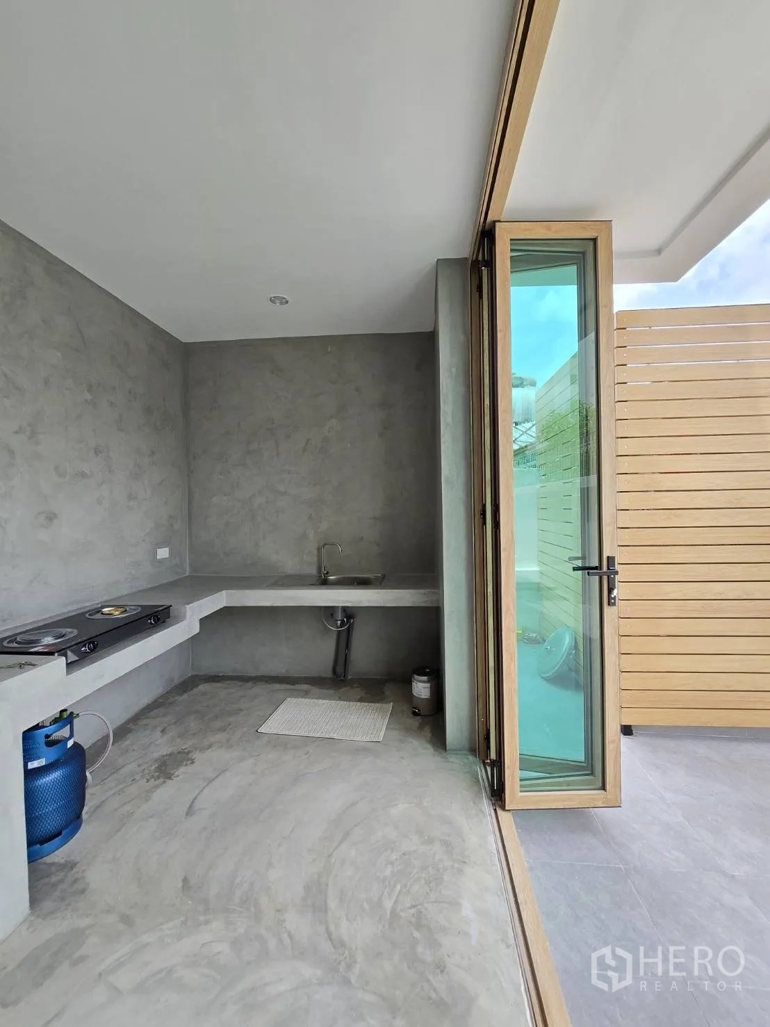 Detached House for sale in Suan Luang, Bangkok - Outdoor Thai kitchen with concrete counters, sink and gas hob area.