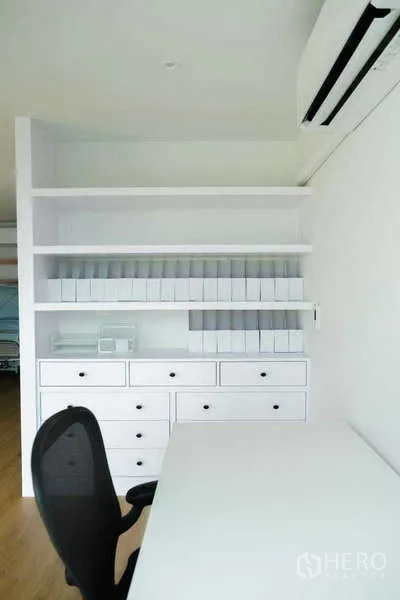 Home Office for rent in Phra Khanong, Bangkok - Compact office corner with built-in white shelving, drawers and a work desk with chair.