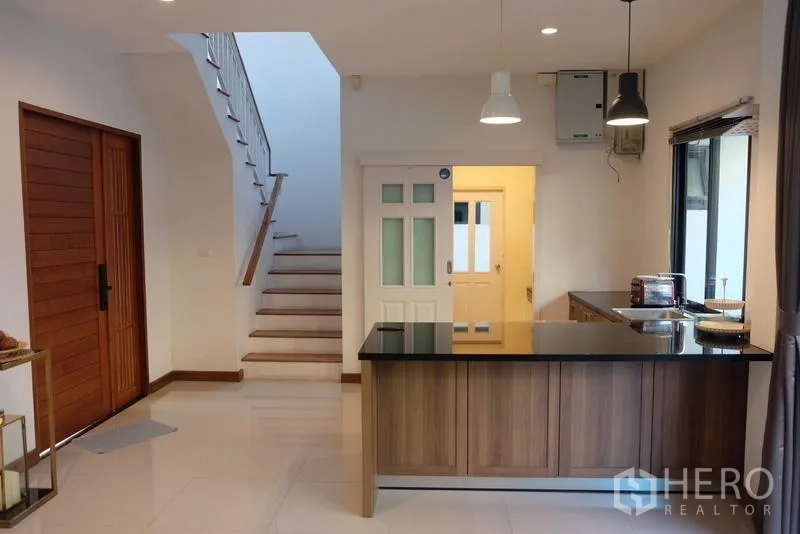 Detached House for rent in Bang Phli, Samut Prakan - Open kitchen with island, pendant lights and stairway view.