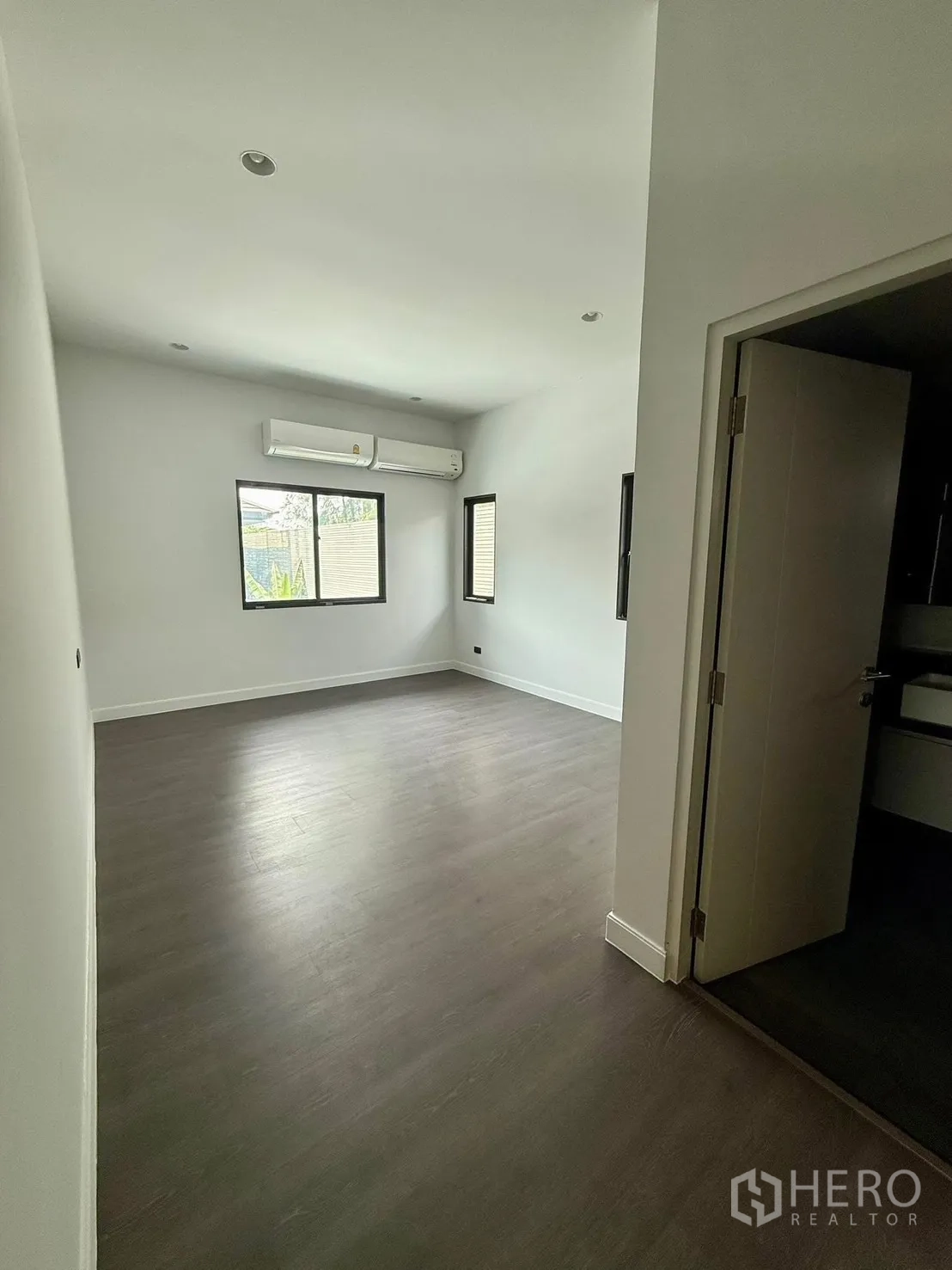 Detached House for rent in Bang Kapi, Bangkok - Upper bedroom with wood flooring, multiple windows and ensuite access.