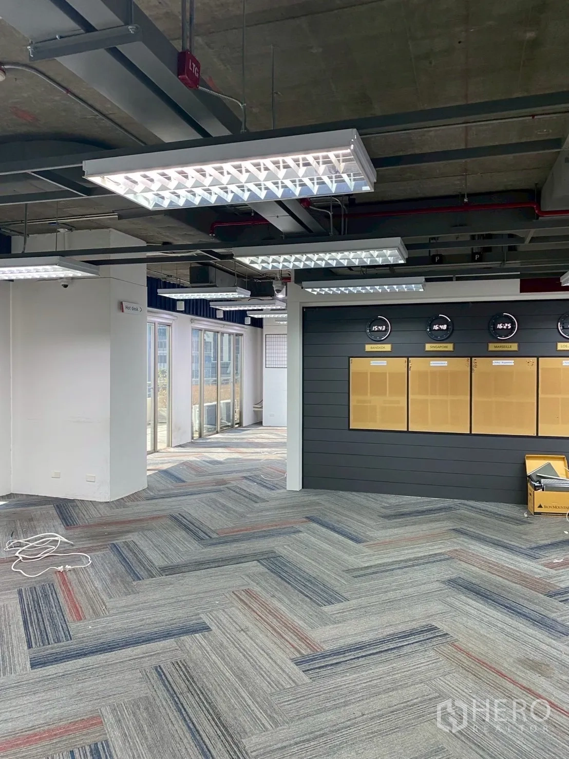 Office Space for rent in Watthana, Bangkok - Open workspace with feature wall and clocks beside doors to terrace.