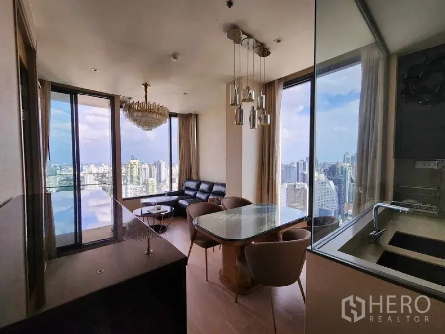 Condominium for rent - Kitchen, dining table and living area framed by floor-to-ceiling windows and skyline views.