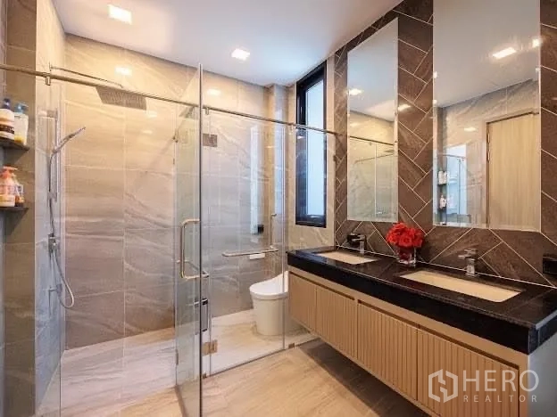 Detached House for sale in Prawet, Bangkok - Luxury bathroom featuring glass-enclosed rain shower and double vanity with large mirrors.