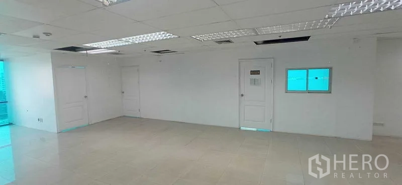 Office Space for rent in Huai Khwang, Bangkok - Office wall with two doors and a small interior window under a grid ceiling.