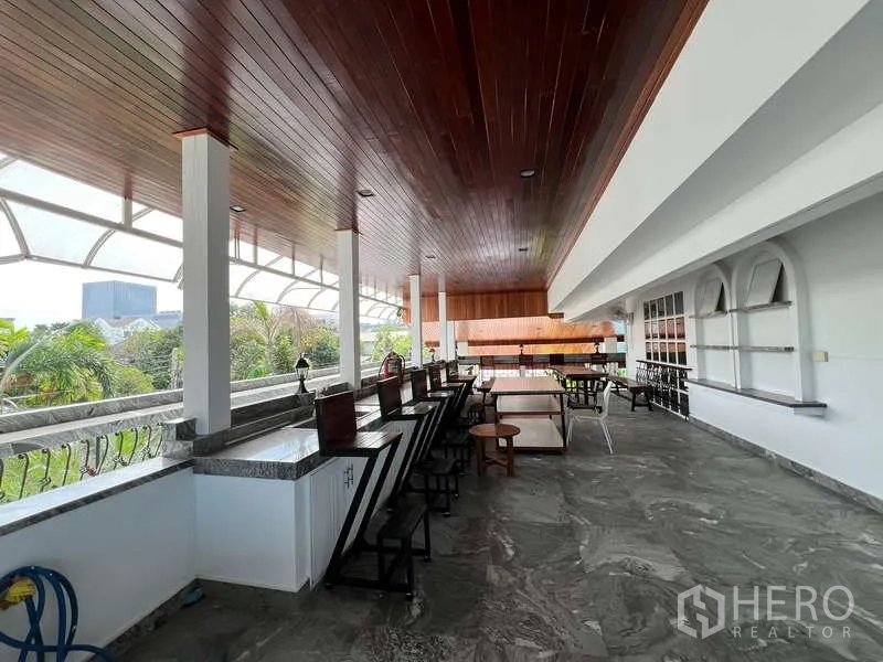 Detached House for rent in Chatuchak, Bangkok - Large covered terrace with wood ceiling, long counter seating and open garden views.