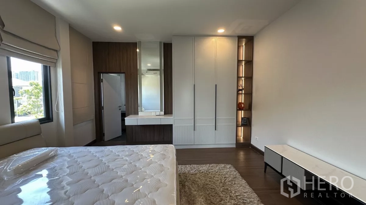 Detached House for rent in Bang Phli, Samut Prakan - Sunlit bedroom with built-in wardrobe, vanity and large window.