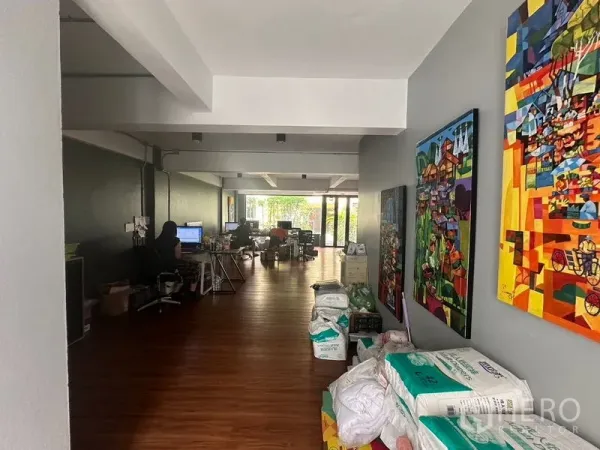 Home Office for rent in Sathon, Bangkok - Hallway lined with colorful artwork leading to a large open-plan office zone.