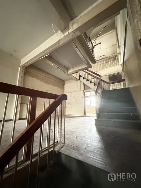 Shophouse for rent or sale in Watthana, Bangkok - Interior staircases showing split-level layout and natural light.