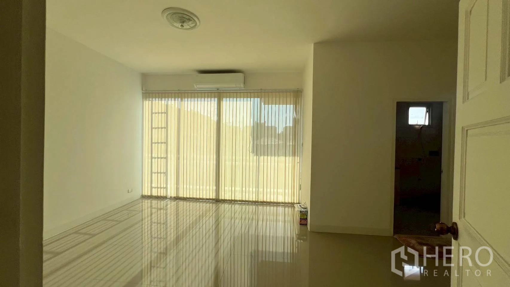 Home Office for rent in Wang Thonglang, Bangkok - Bright room with sliding glass doors, vertical blinds and a small adjacent room.