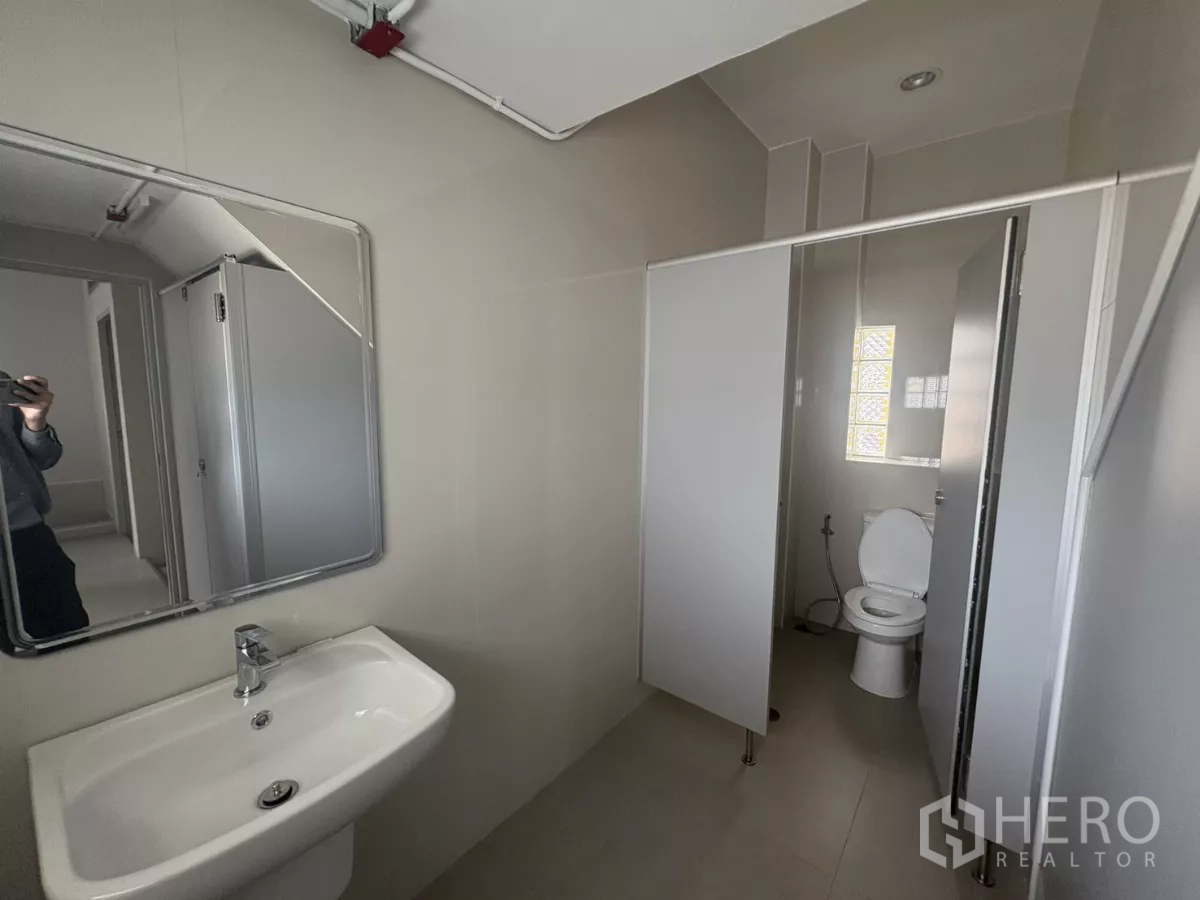 Factory for rent in Bang Phli, Samut Prakan - Restroom with sink and partition leading to a toilet cubicle.