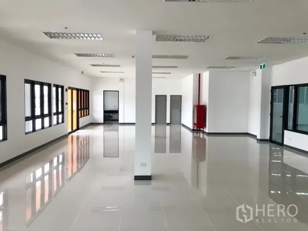 Factory for rent in Wang Noi, Phra Nakhon Si Ayutthaya - Bright office space with tiled flooring, grid ceiling lights, and large black-framed windows.