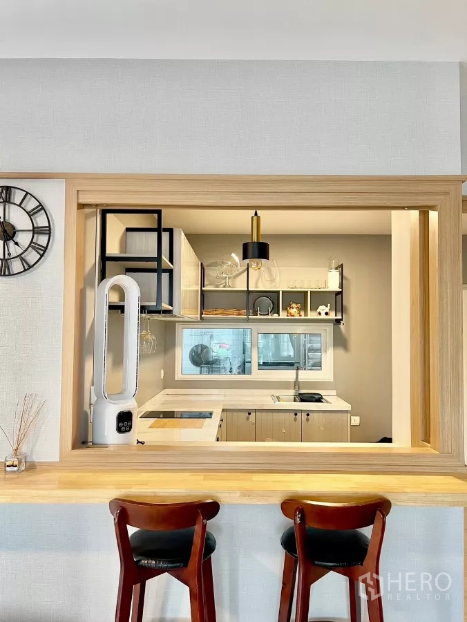 Detached House for rent in Prawet, Bangkok - Breakfast bar opening to a stylish kitchen with stools and open shelving.