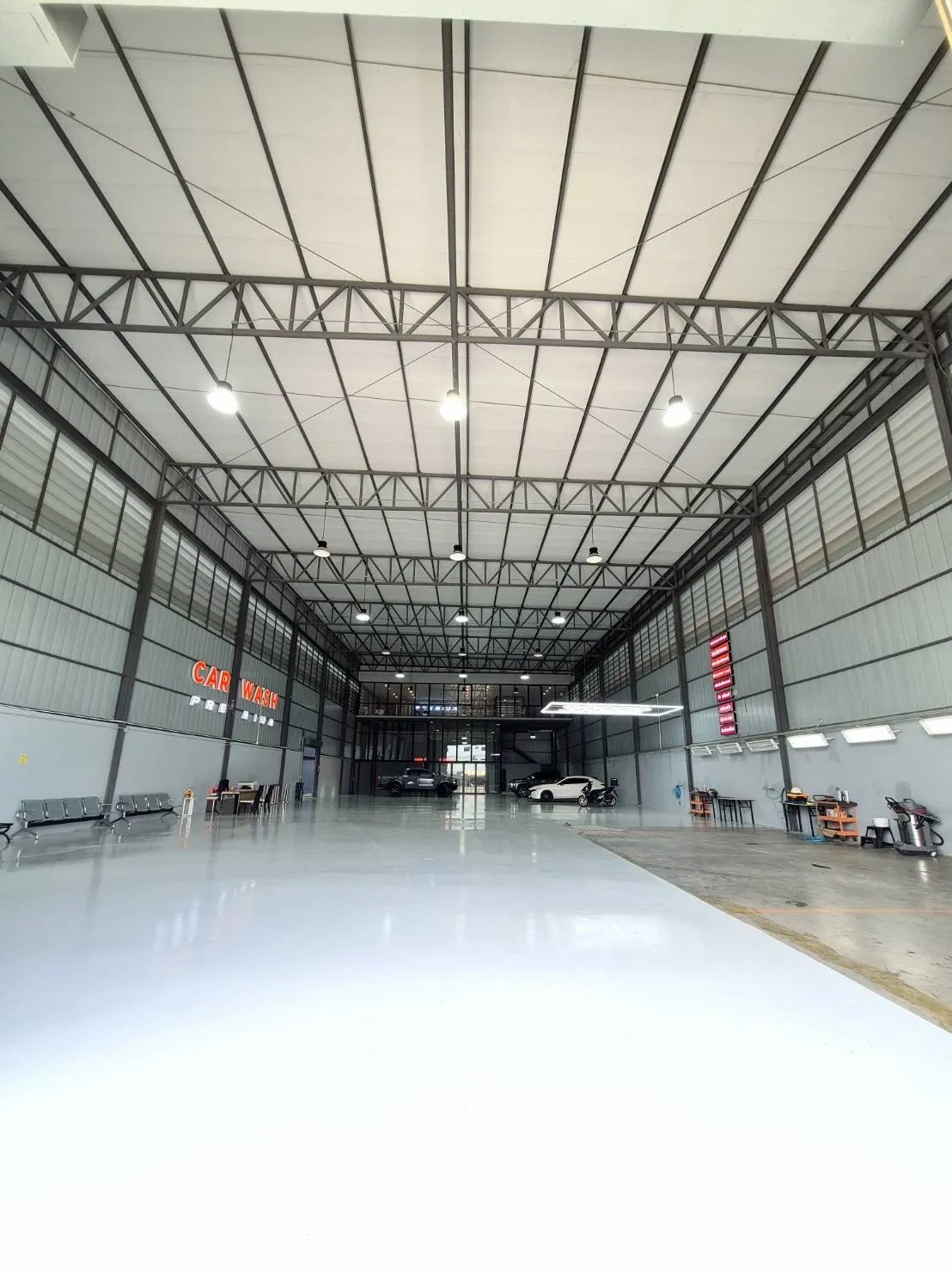 Warehouse for rent in Sai Mai, Bangkok - Open industrial hall with polished floor, benches, workstations, and overhead lights.