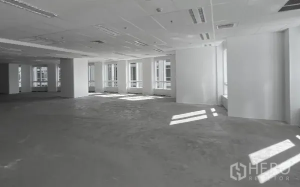 Office Space for rent - Bright open-plan office floor with white walls, drop ceiling lighting, and large windows.