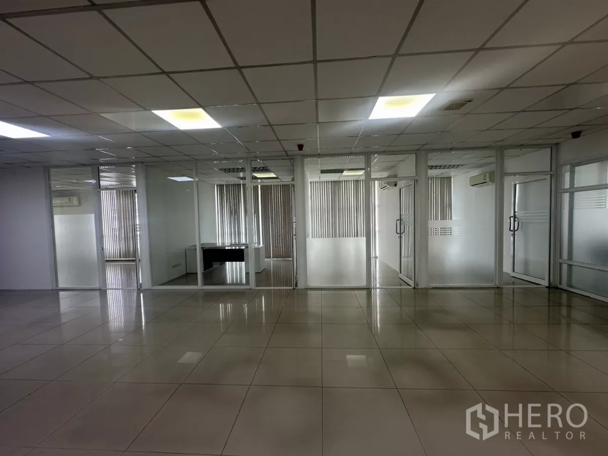 办公空间 出租在Huai Khwang, Bangkok - 一排玻璃墙独立办公室，带磨砂条纹与竖百叶窗。