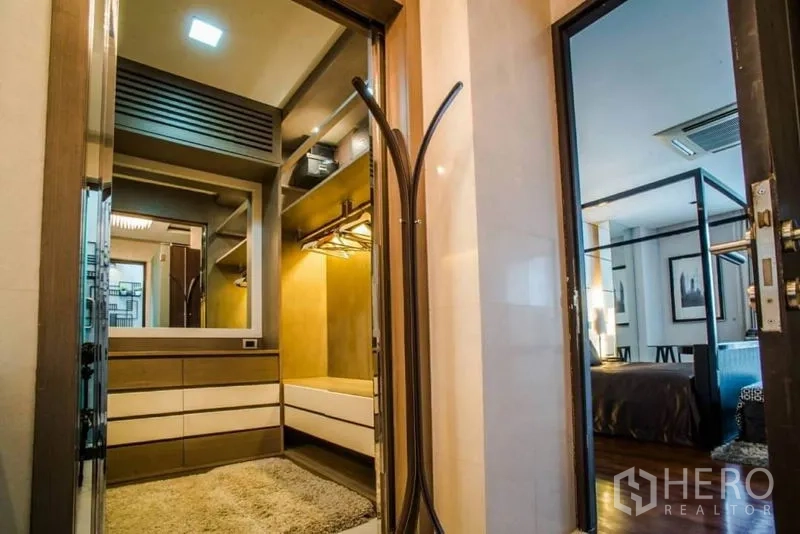 Townhouse for rent or sale in Watthana, Bangkok - Built-in walk-in closet with drawers, shelving and warm lighting