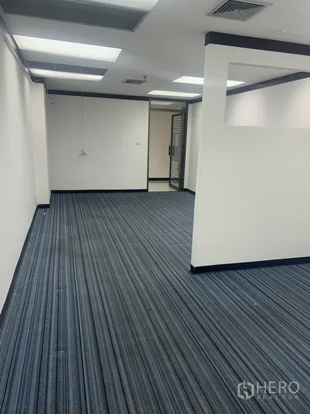 Office Space for rent in Pathum Wan, Bangkok - Long office room with carpet tiles, half-height divider and ceiling air vents.