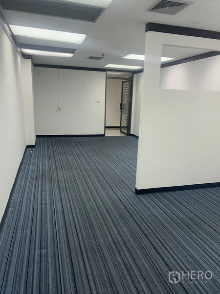 Office Space for rent in Pathum Wan, Bangkok - Long office room with carpet tiles, half-height divider and ceiling air vents.
