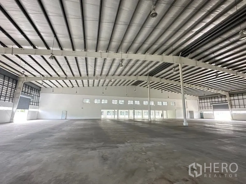 Factory for rent in Pathum Thani - Warehouse hall facing internal office building and multiple windows.