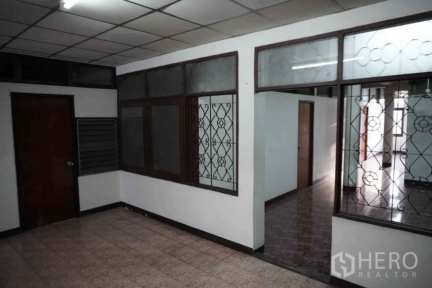 店屋 出租在Watthana, Bangkok - 室内走廊，带花格防护窗、地砖与多扇门。