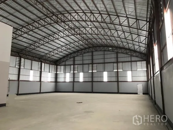 Factory for rent or sale in Bang Len, Nakhon Pathom - High-clearance warehouse interior with arched steel truss roof and ventilated walls.