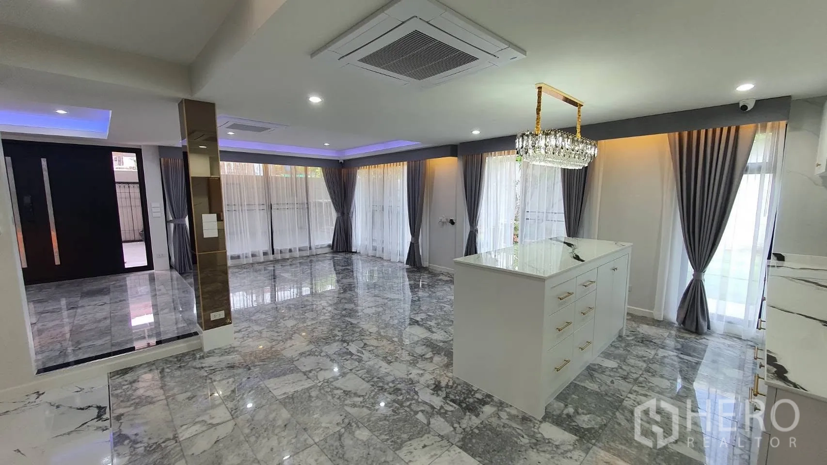 独栋房屋 for rent in Lat Phrao, Bangkok - 开放式客餐厅，大理石地面、中岛与落地窗帘。