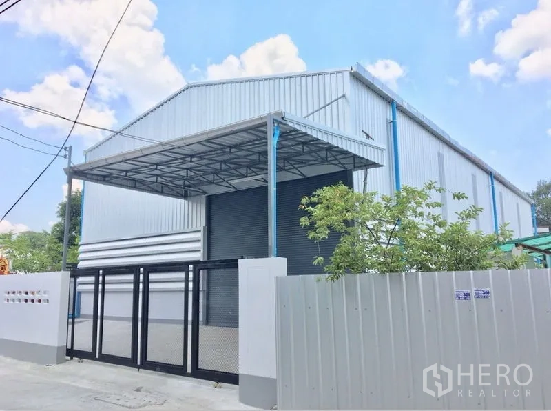 货栈 出租在Din Daeng, Bangkok - 仓库正立面，金属板外墙，带安全大门与遮雨装卸区，位于Huai Khwang