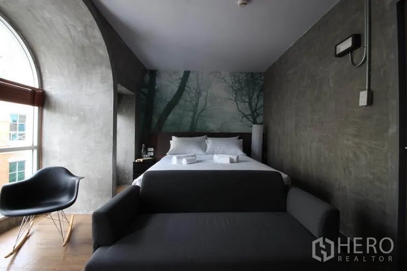 Office Space for rent or sale in Bang Rak, Bangkok - Suite-style bedroom with an arched window, wall mural, and sofa.