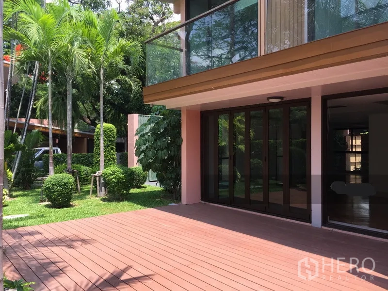 Detached House for rent in Sathon, Bangkok - Timber deck with sliding glass doors and an upper balcony facing a lush garden