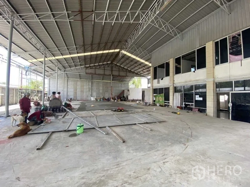 Warehouse for rent in Khlong Luang, Pathum Thani - Wide interior shot highlighting the high ceiling and adjoining office area.