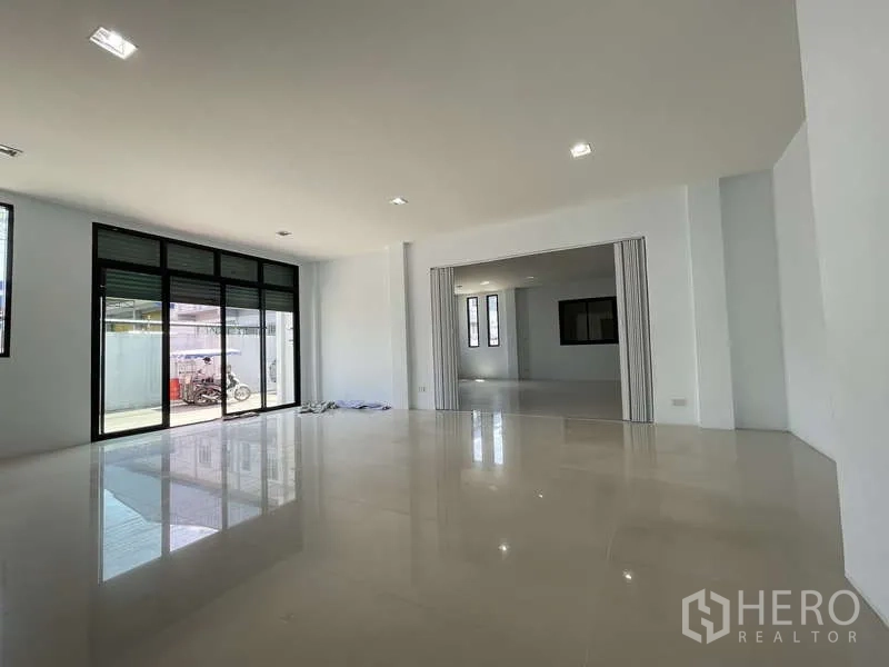 Factory for rent in Ban Phaeo, Samut Sakhon - Ground-floor office area with large windows and sliding glass door to the loading zone.