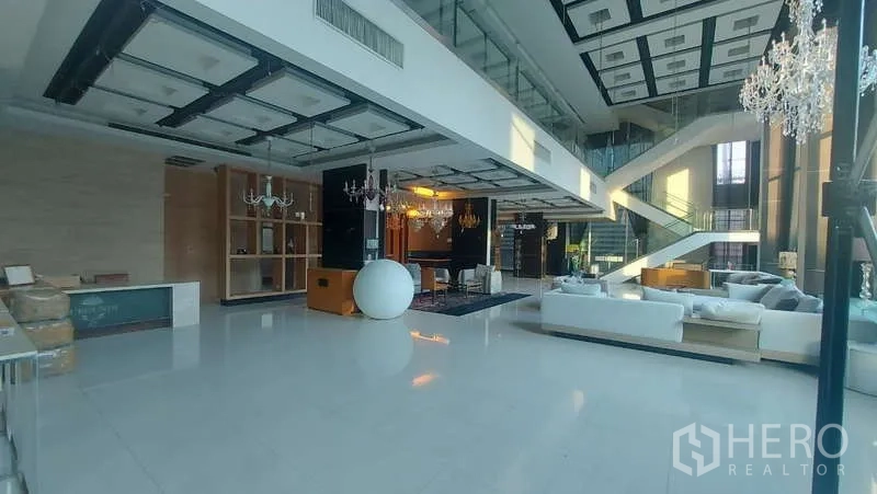 Retail Space for rent in Watthana, Bangkok - Double-height showroom with chandeliers, white flooring, mezzanine and feature staircase