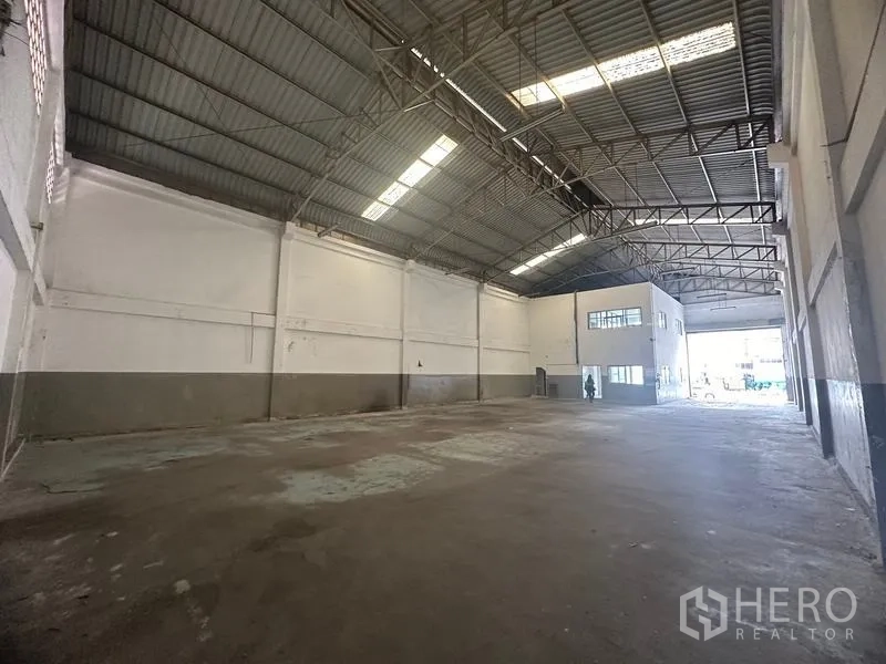 Factory for rent in Khlong Luang, Pathum Thani - Wide warehouse hall with high ceiling, skylights and a two-storey office pod.