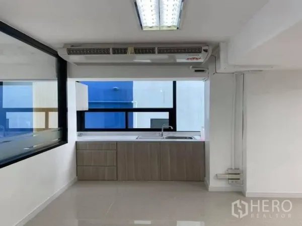 Office Space for rent in Suan Luang, Bangkok - Office pantry with sink, base cabinets and a large window for natural light.