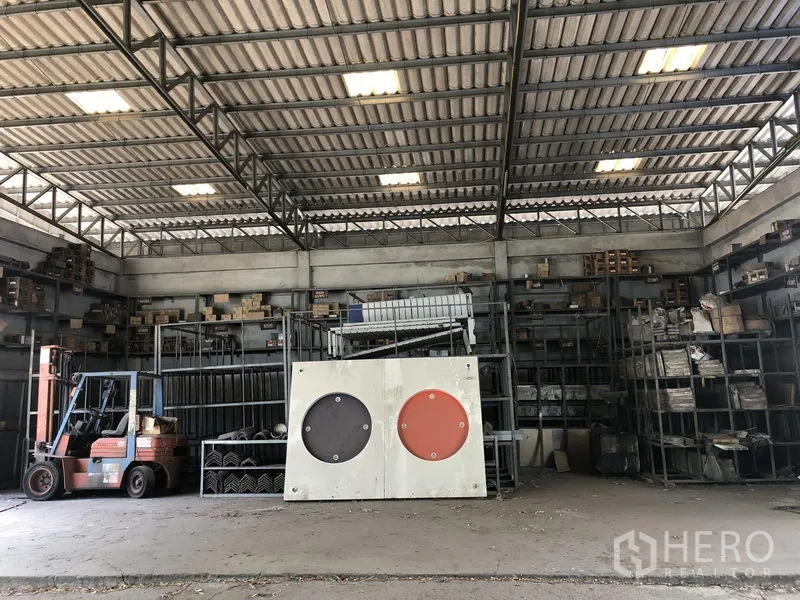 货栈 出租或出售在Lam Luk Ka, Pathum Thani - 仓库内部配货架、叉车和金属桁架屋顶。