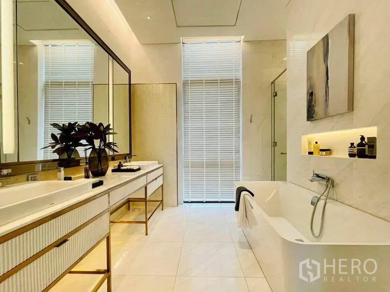 Condominium for sale in Pathum Wan, Bangkok - Bright bathroom with double sinks, glass shower and soaking tub with recessed shelf.