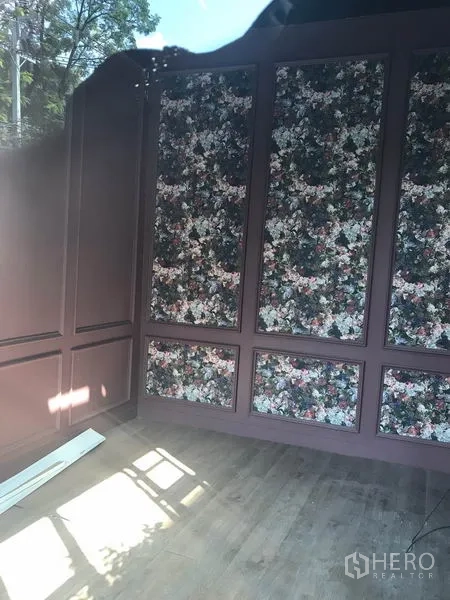 Retail Space for rent in Watthana, Bangkok - Compact retail interior with floral wall panels and wood flooring, natural light streaming in.
