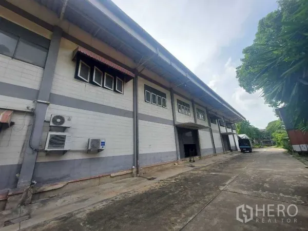 货栈 出租在Min Buri, Bangkok - 仓库外立面带装卸月台与卷帘门，高挑雨棚和宽阔车道