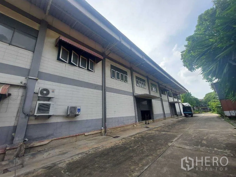 货栈 出租在Min Buri, Bangkok - 仓库外立面带装卸月台与卷帘门，高挑雨棚和宽阔车道