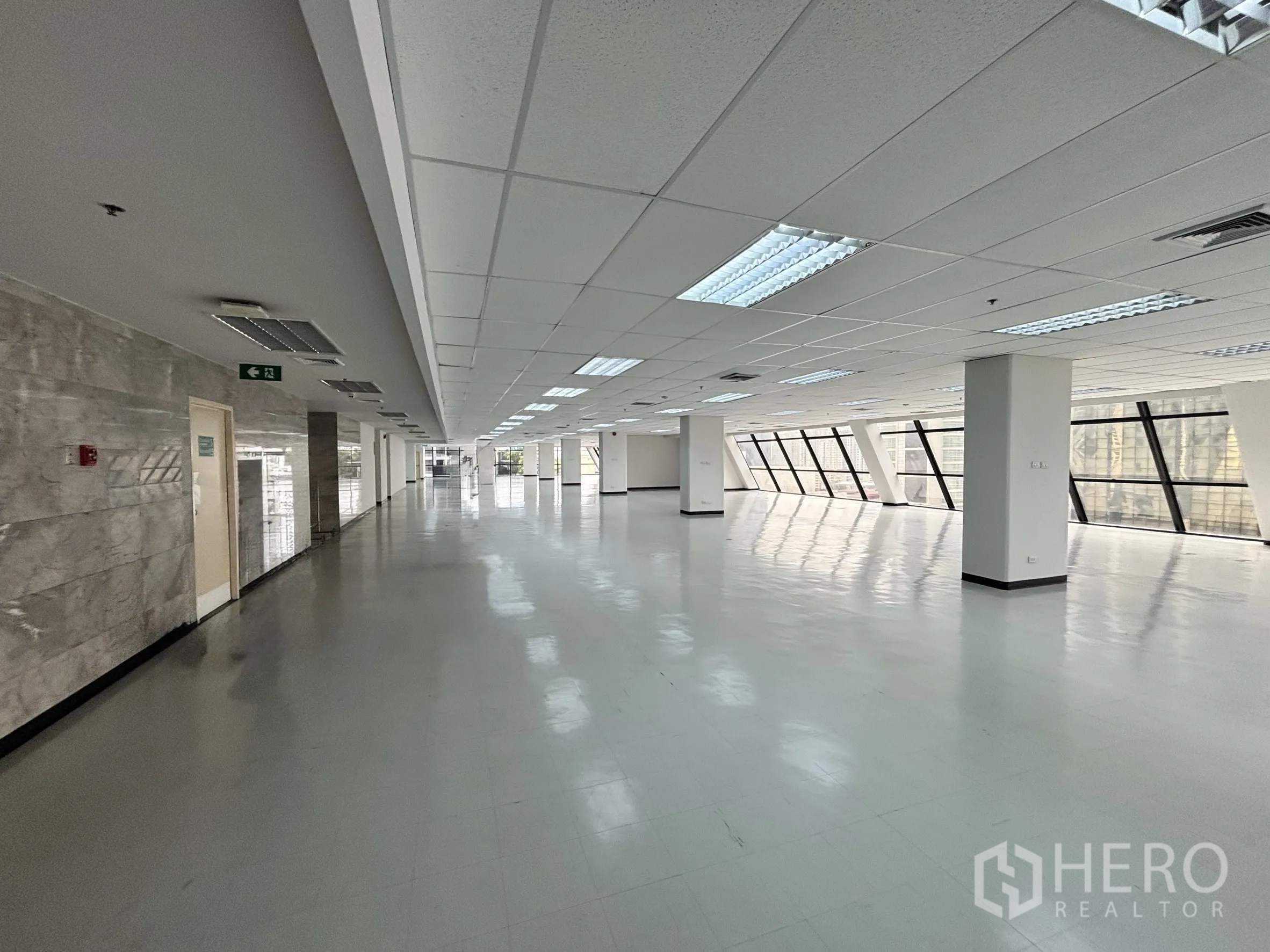 Office Space for rent in Ratchathewi, Bangkok - Corridor-style section featuring marble wall accents, ceiling lights, and rows of angled glass panels.