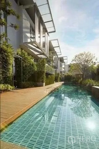 联排别墅 出租在Huai Khwang, Bangkok - 长形瓷砖泳池沿联排别墅延伸，设日光甲板与绿植。