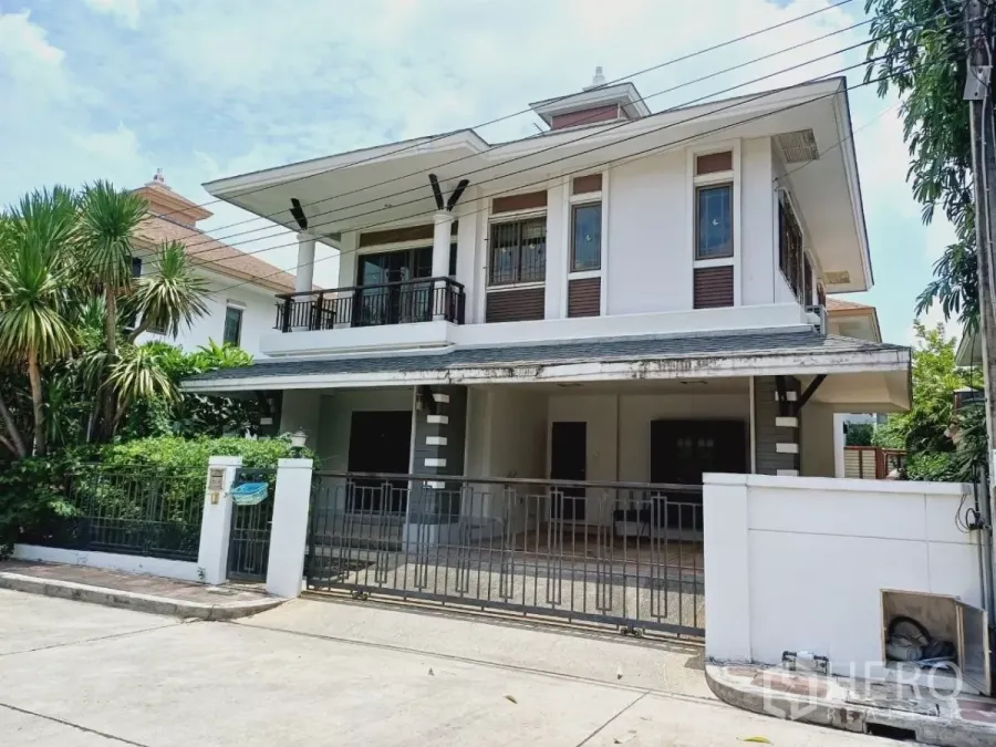 Detached House for rent or sale in Mueang Nonthaburi, Nonthaburi - Two-storey detached house facade with gated driveway, balcony and landscaped front yard in Mueang Nonthaburi.