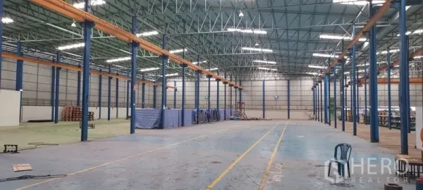 Factory for rent in Phra Pradaeng, Samut Prakan - Vast warehouse hall with high steel truss roof and clear span columns.